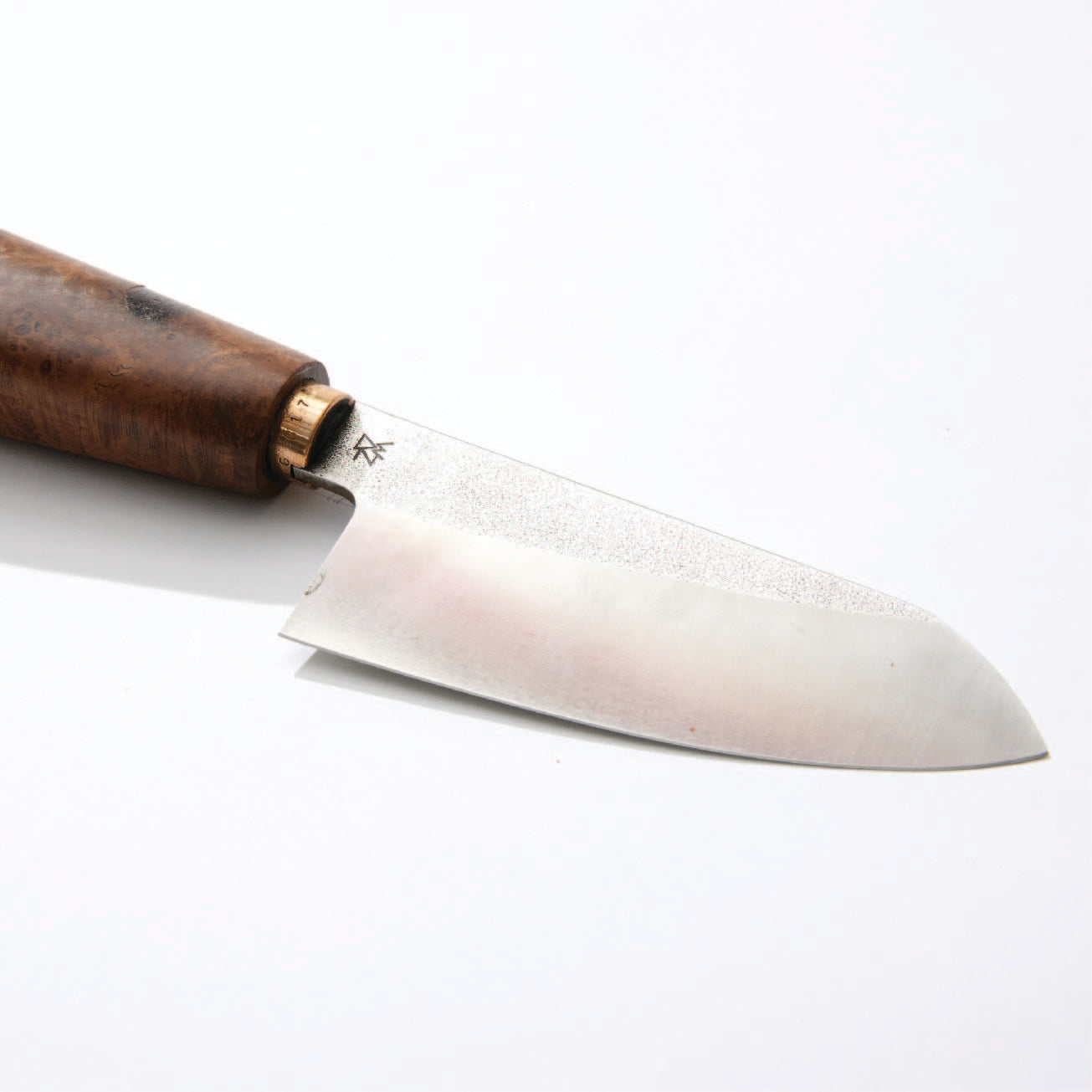 a knife with a wooden handle on a white surface
