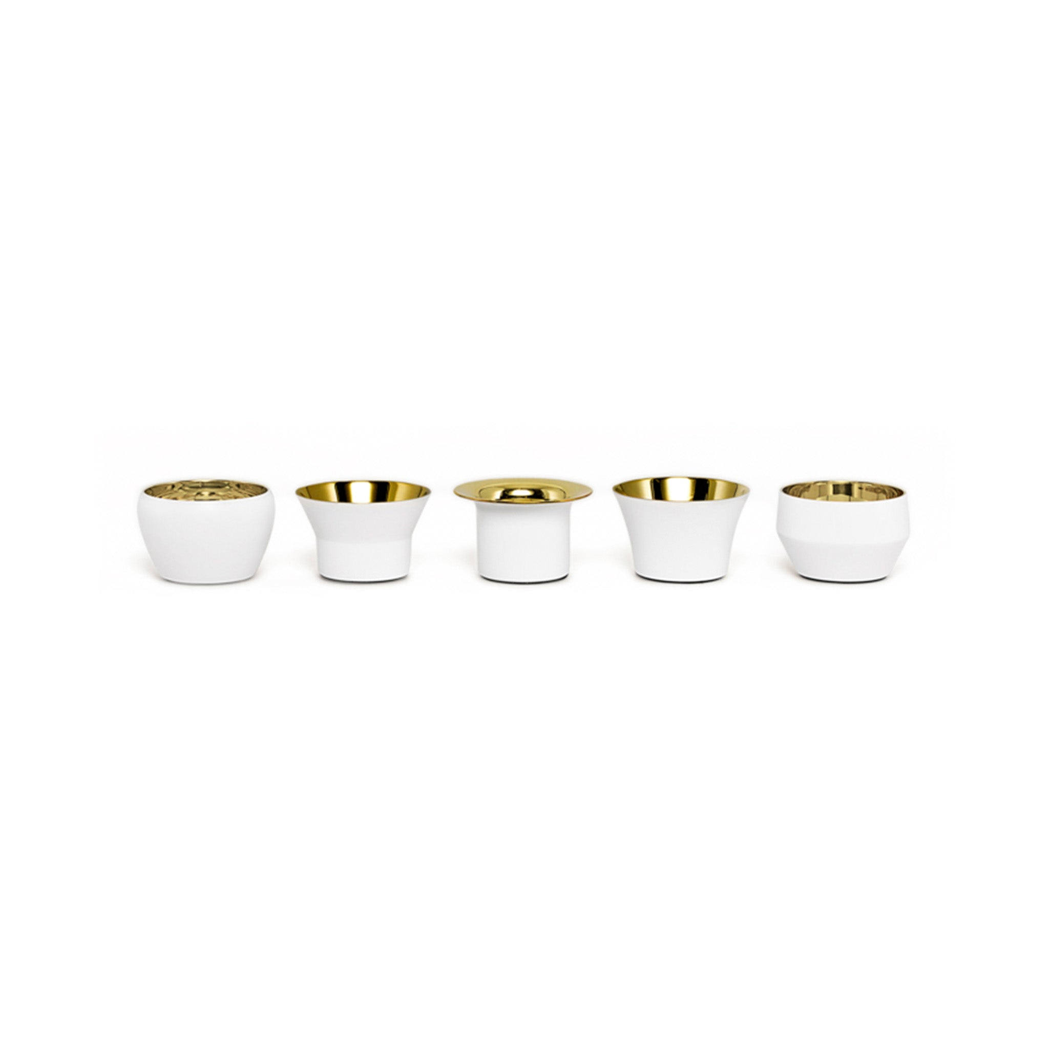 a set of five white and brass tealights by skultuna in a row on a white background