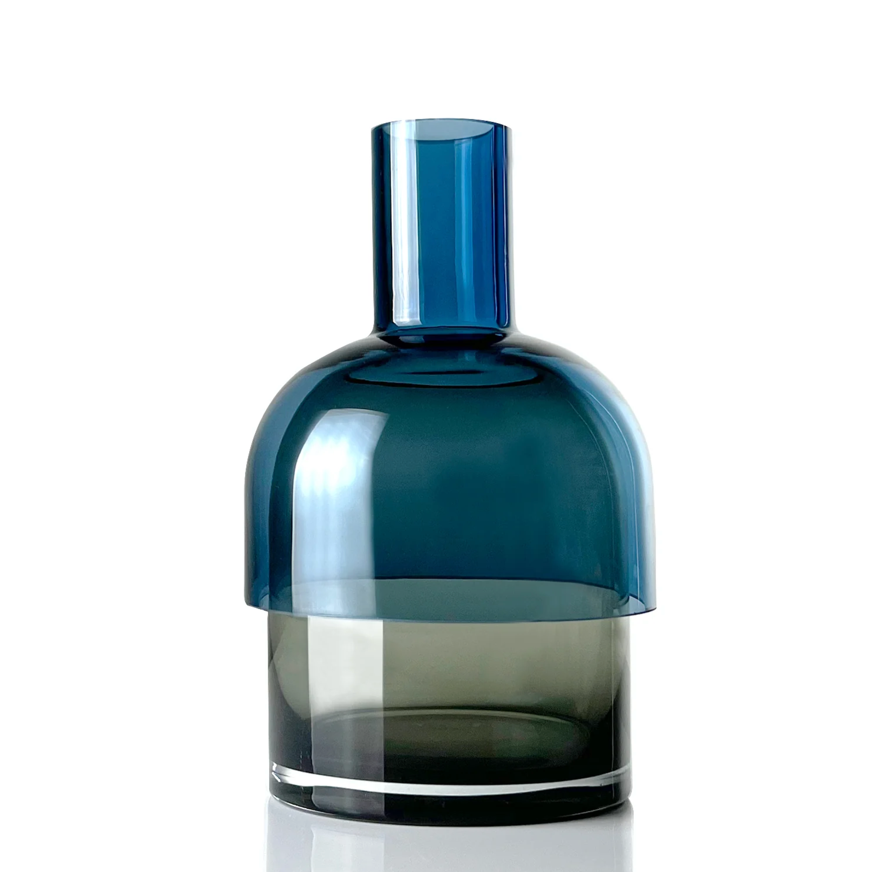 a blue and grey glass flip vase with the barrow side up sitting on top of a white table