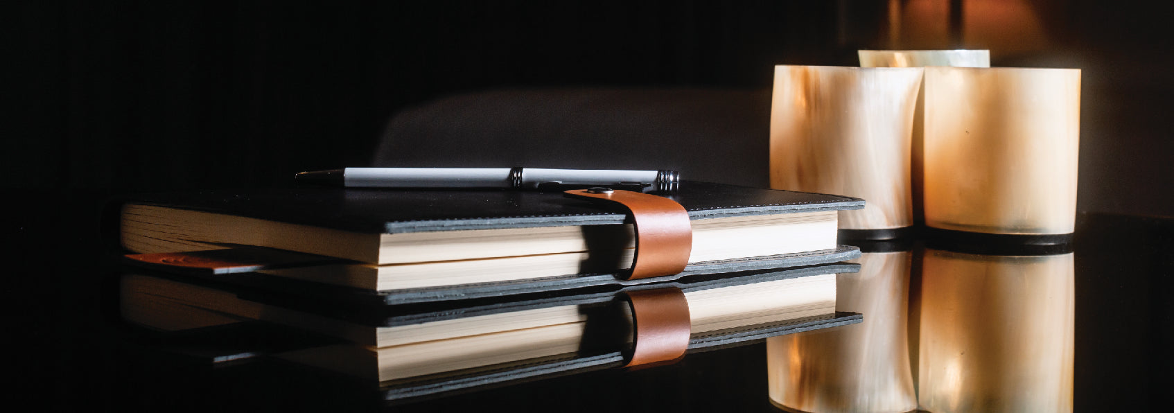 a vegan laether black and brown journal with a pen on top of it 