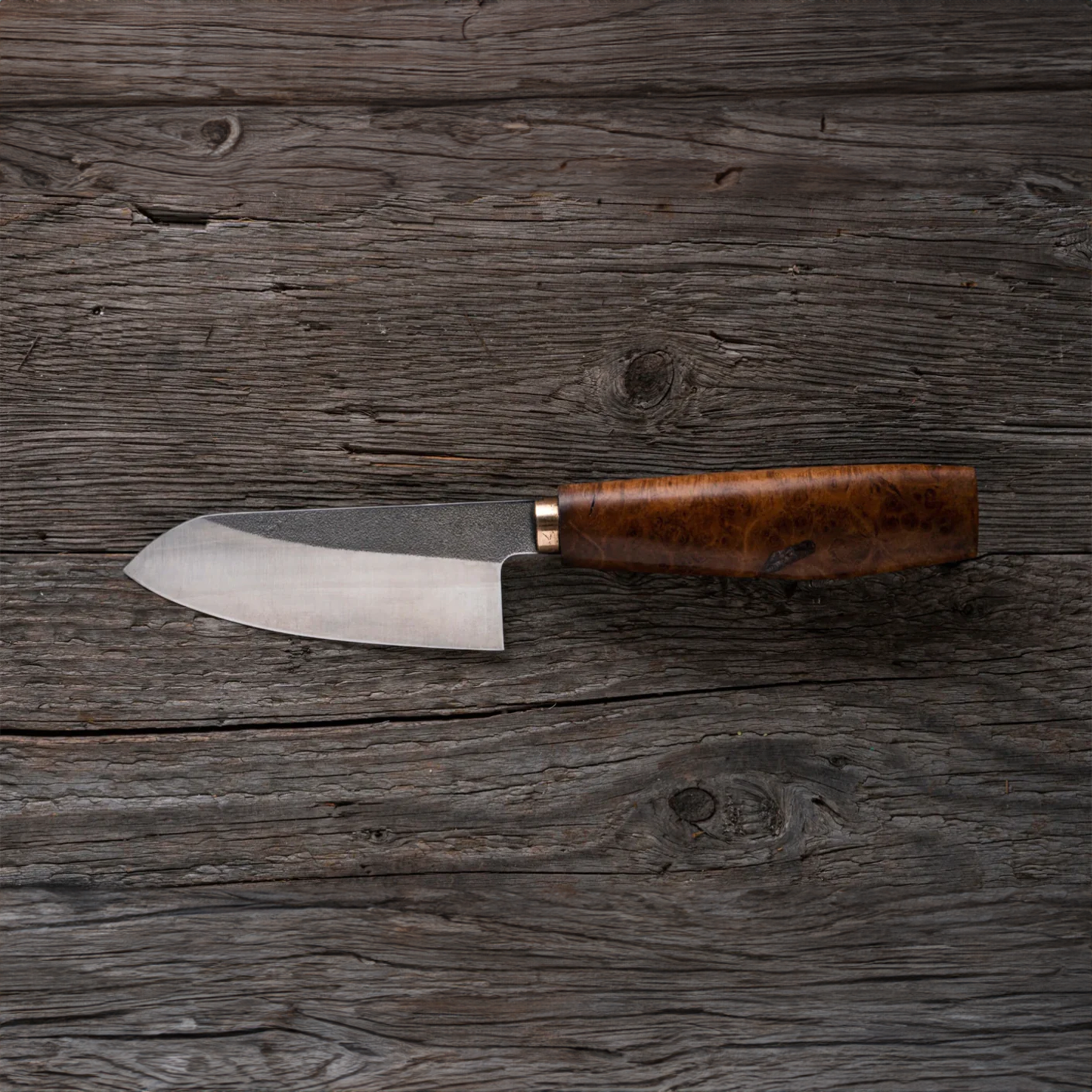 a knife with a wooden handle on a wooden table