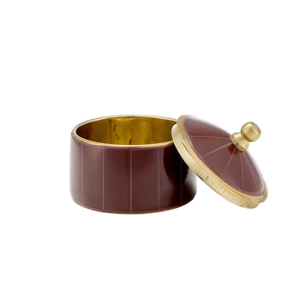 A small cylindrical decorative box with a matching lid, featuring a deep burgundy-red exterior with subtle vertical fluting, a polished gold-toned interior, and a gold-toned rim with a round knob on the lid, set against a solid off-white background.