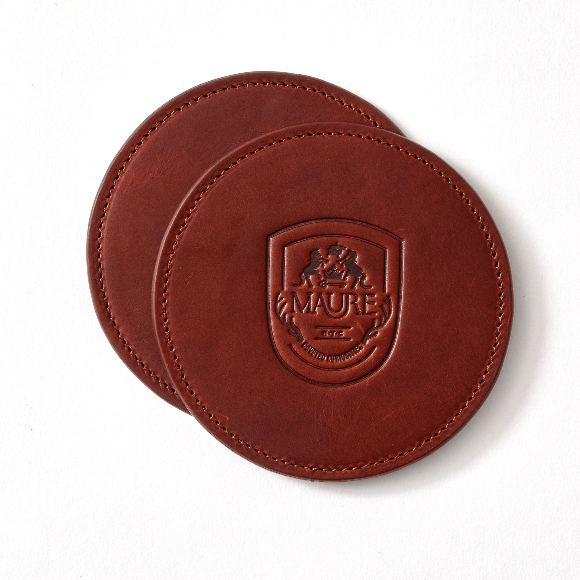 a pair of brown coasters with a logo on them