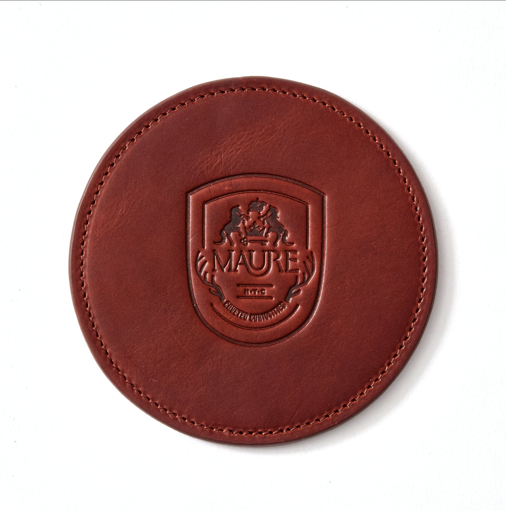 a brown leather coaster with a logo on it