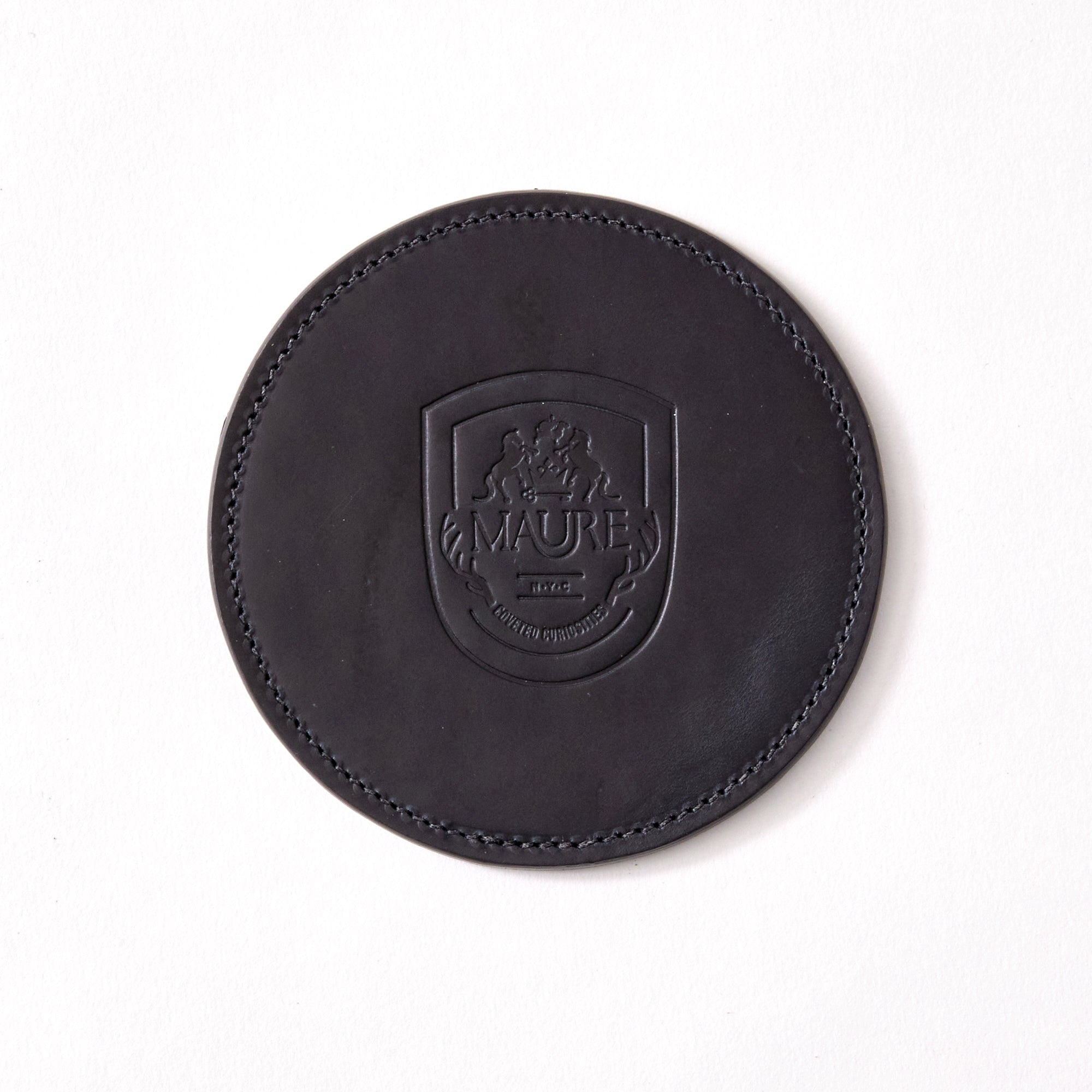 a black leather coaster sitting on top of a white table
