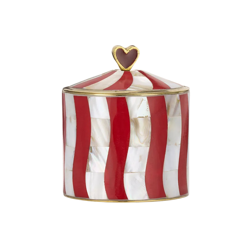 A cylindrical lidded container with a red and white striped shell inlay pattern, gold trim, and a small gold heart-shaped finial on top, set against a plain off-white background.