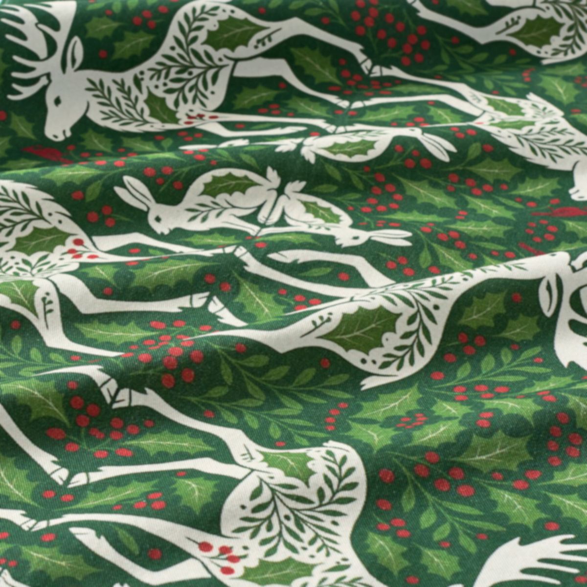 Linen fabric with white deer and holly pattern on a green background