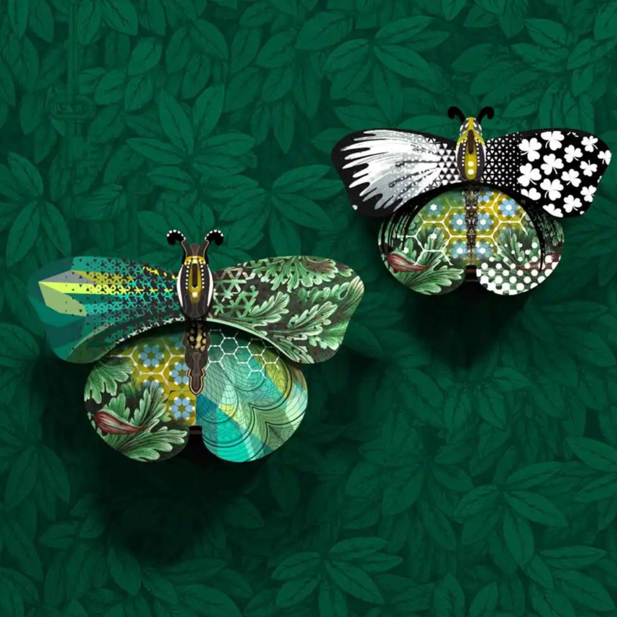 a couple of butterfly storage boxes with wings closed on top of a green wall