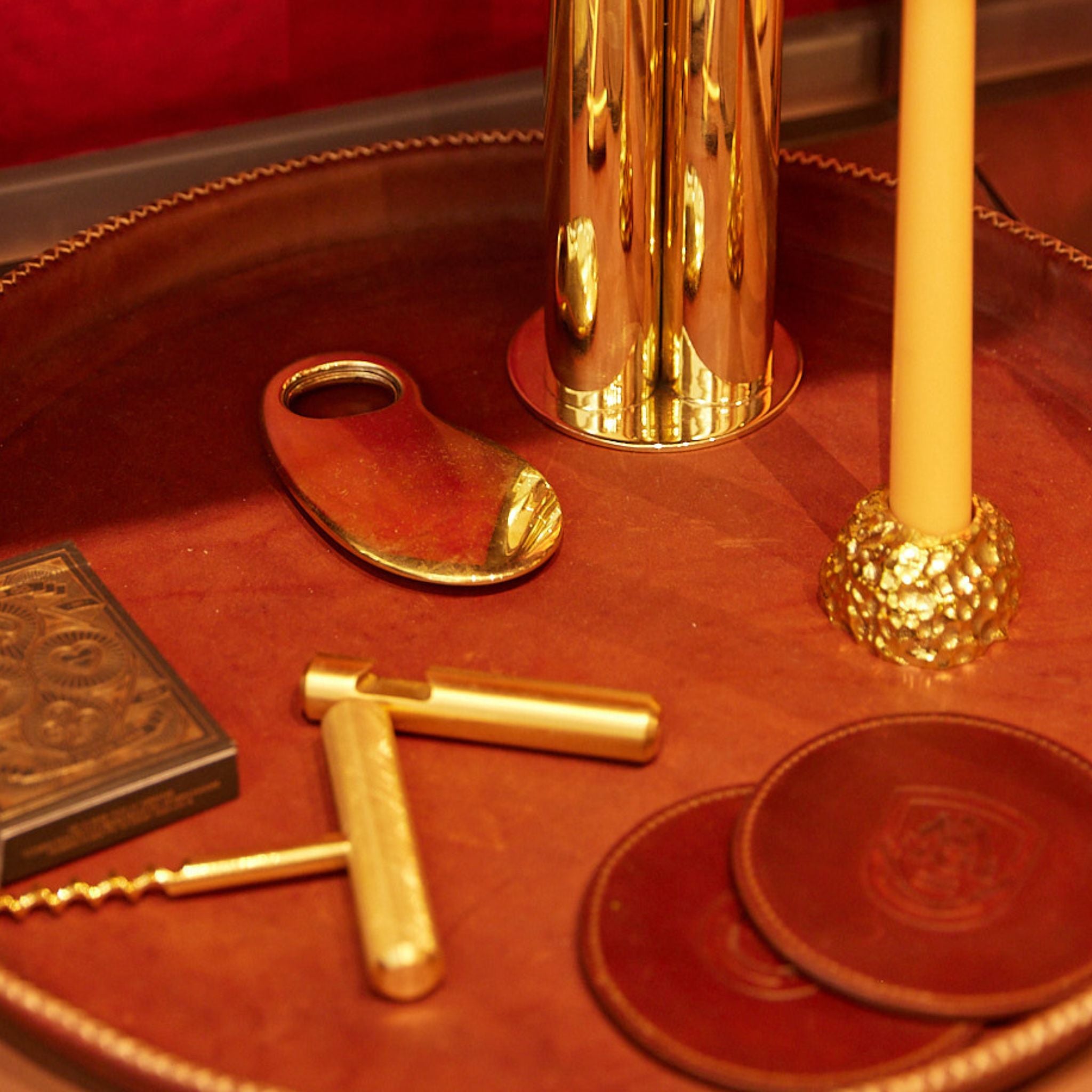 a tray with a candle and some other brass items on it