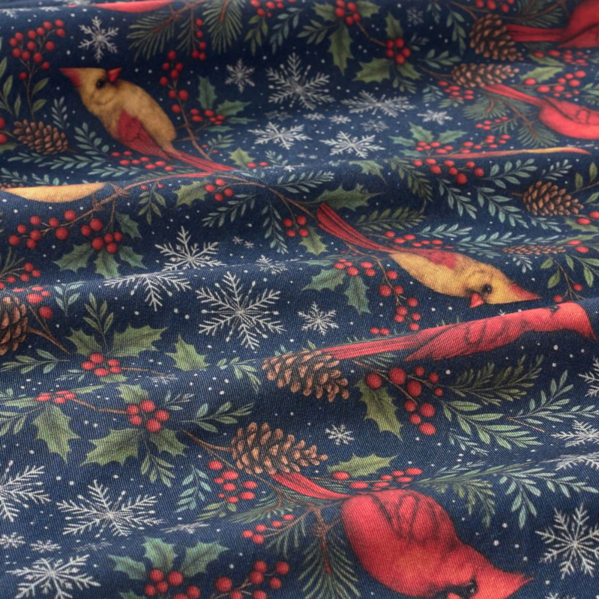 Christmas-themed fabric with red birds, holly leaves, and snowflakes on a blue background.
