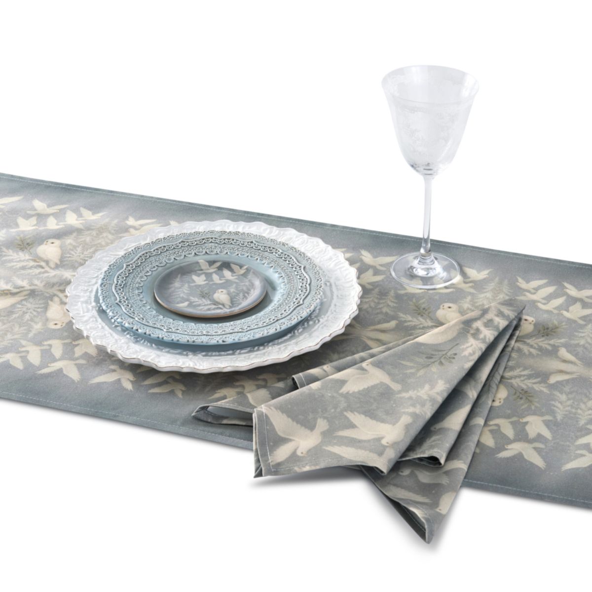 Table setting with gray table runner, plates, and napkin on a white background