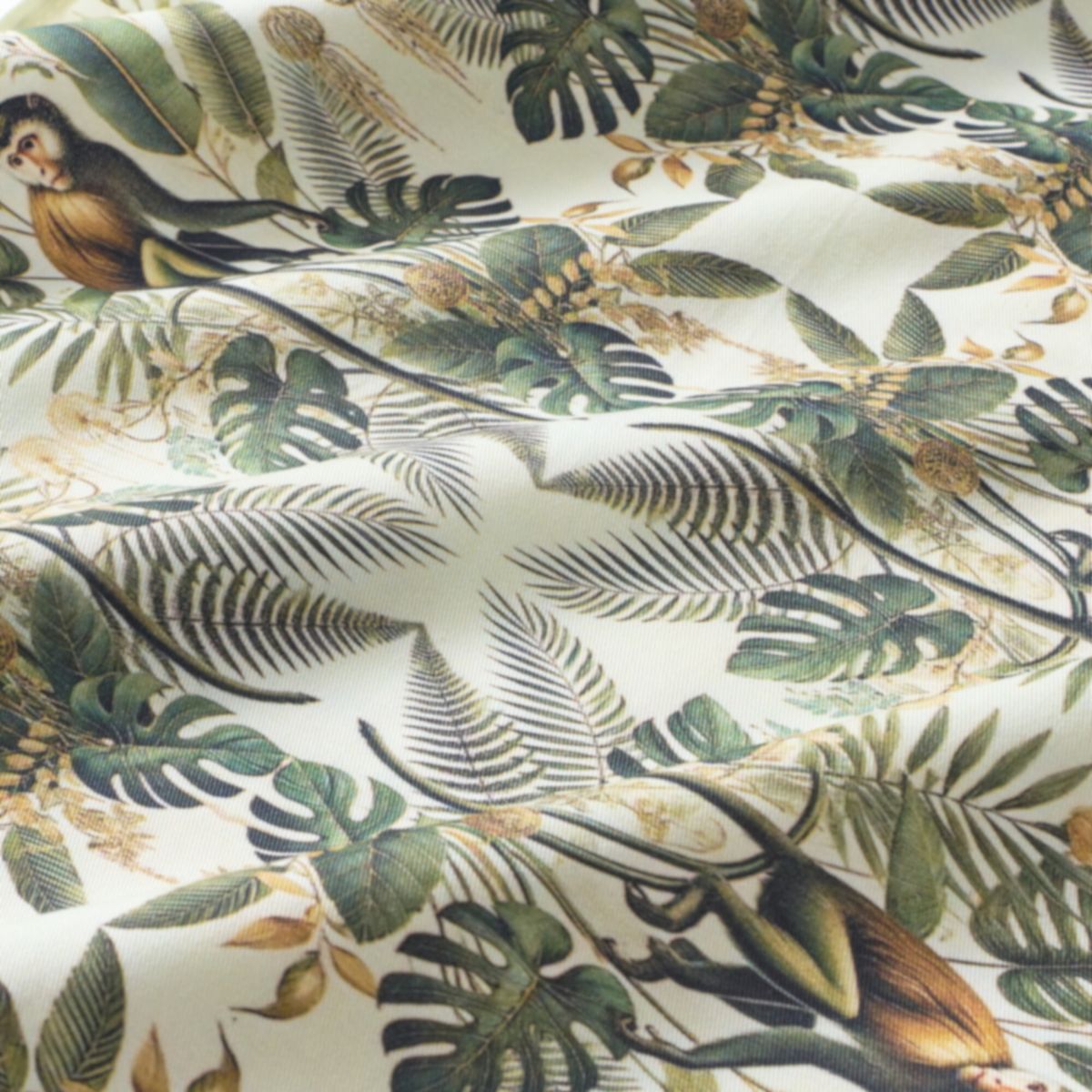 Fabric with a tropical leaf and monkey pattern on a white background