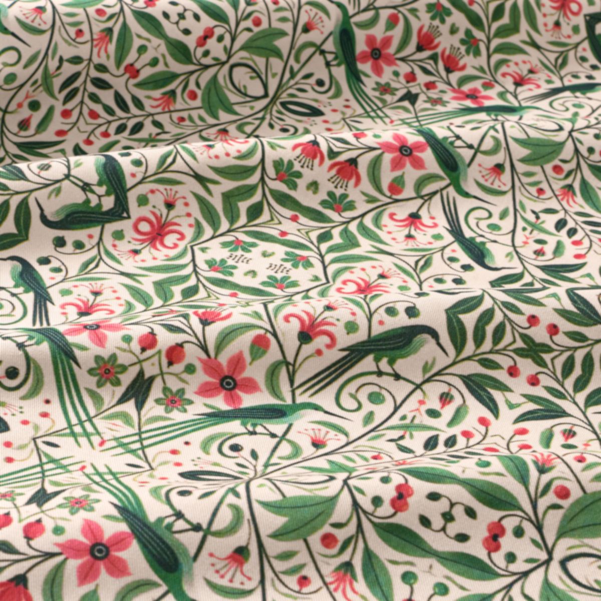 Fabric with a floral and bird pattern in green, pink, and red on a white background