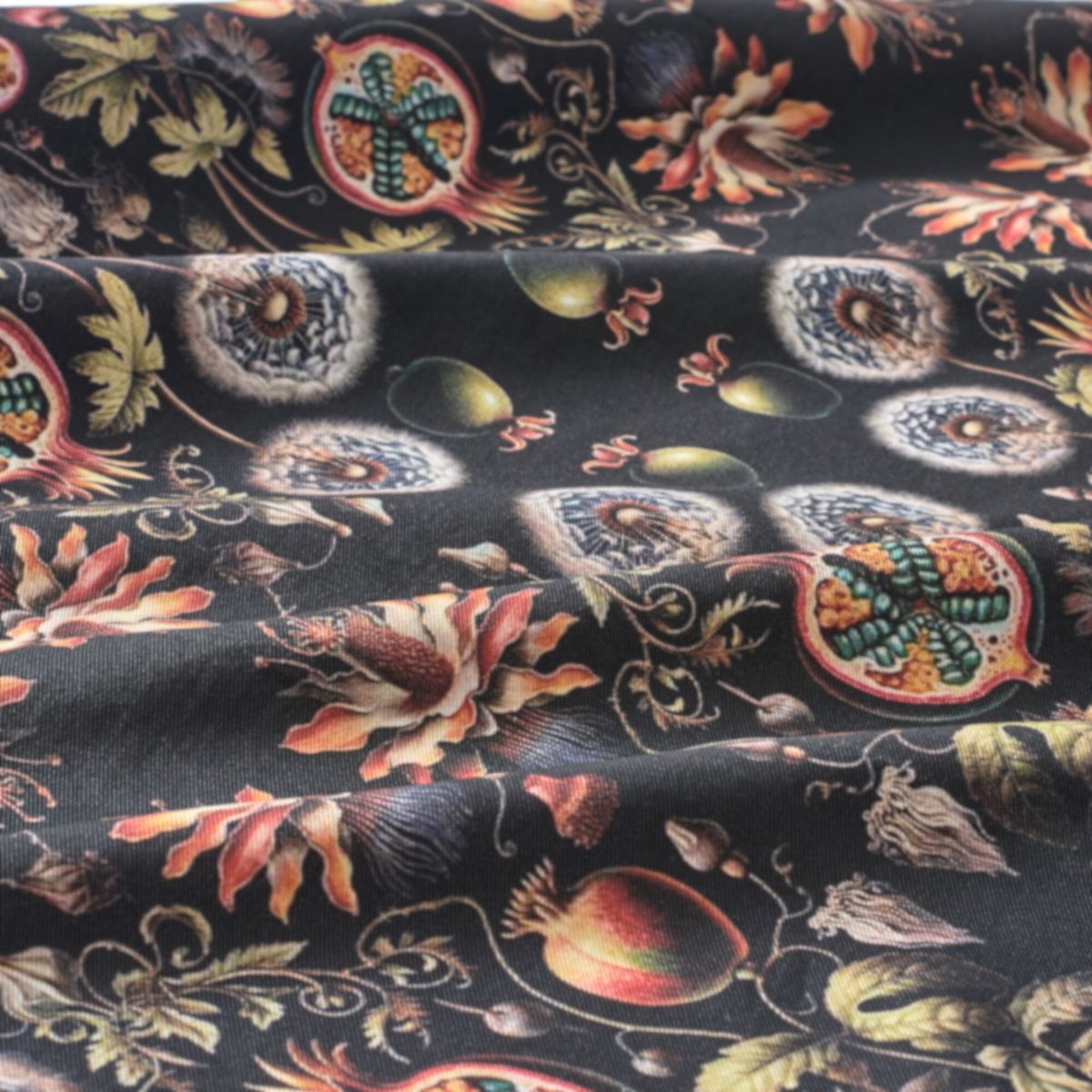 Decorative fabric with intricate floral and fruit pattern on a black background