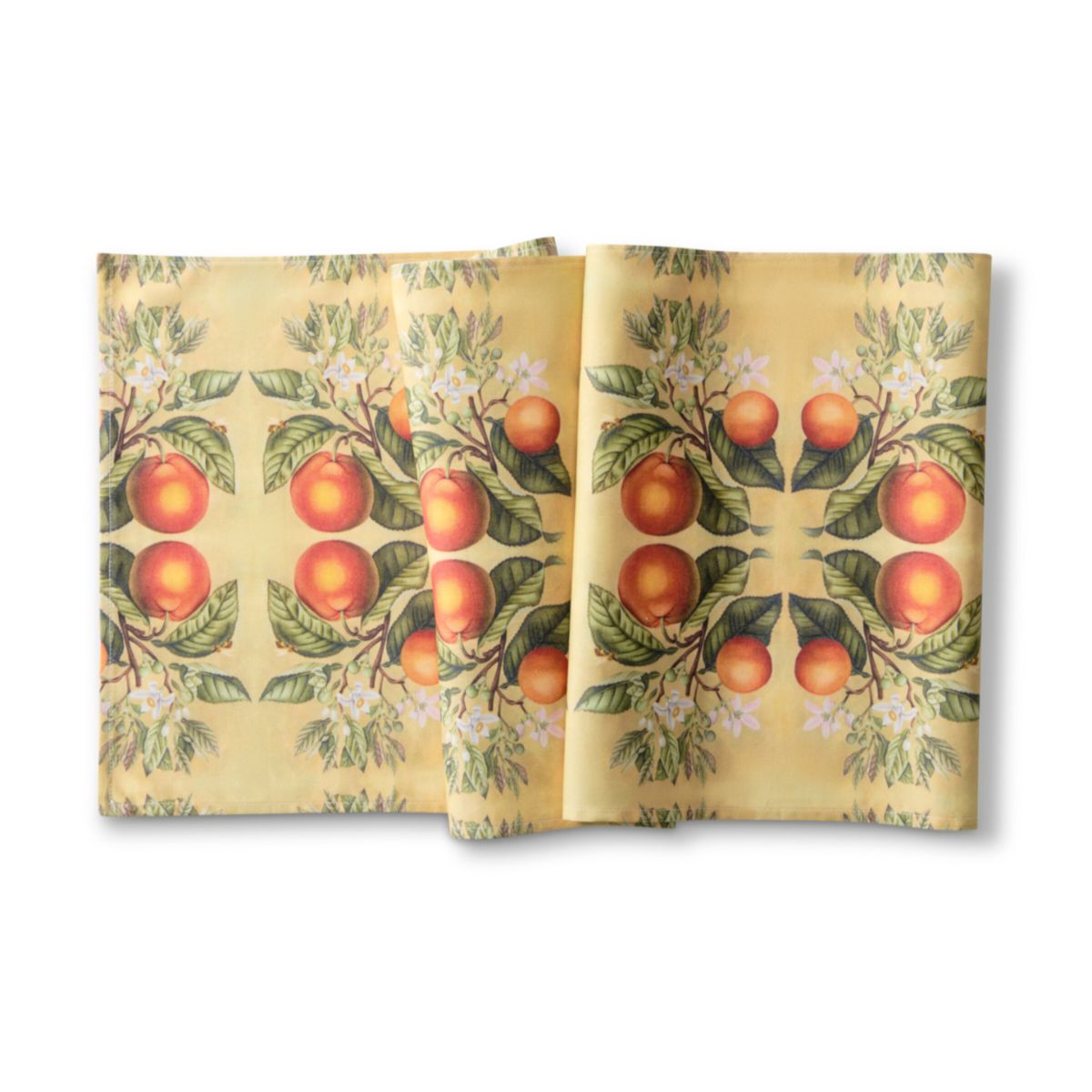 Two folded fabric napkins with a pattern of oranges and leaves on a yellow background.