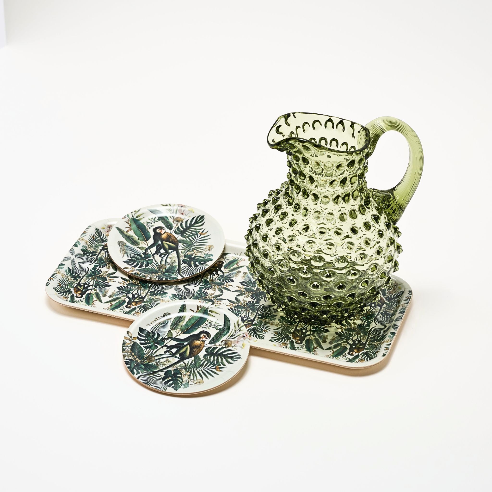 Set of ceramic coasters with bird and leaf design on a white background