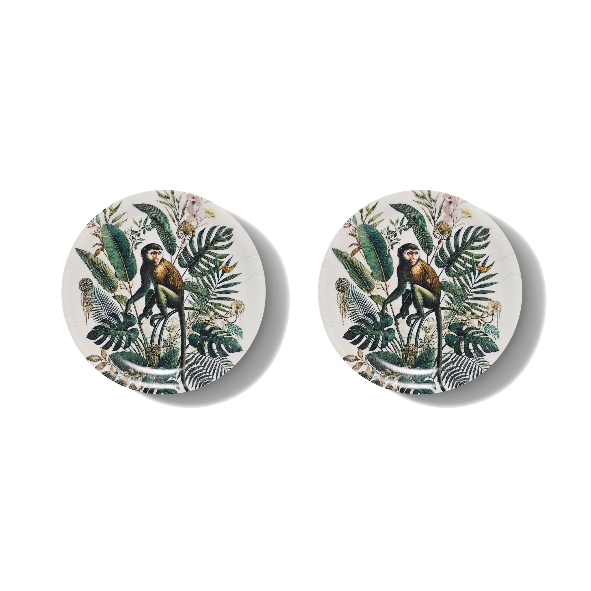 Two round ceramic coasters with monkey and leaf design on a white background
