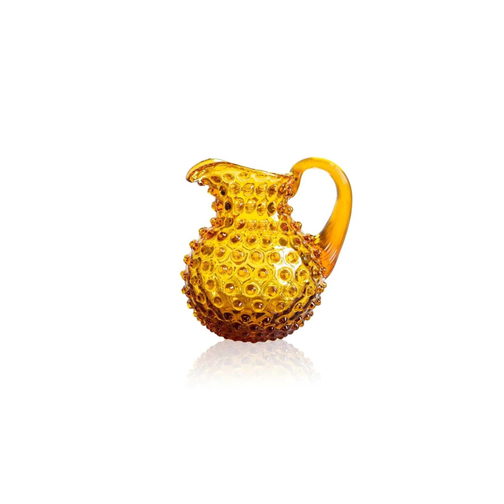 a amber hobnail creamer sitting on top of a white surface