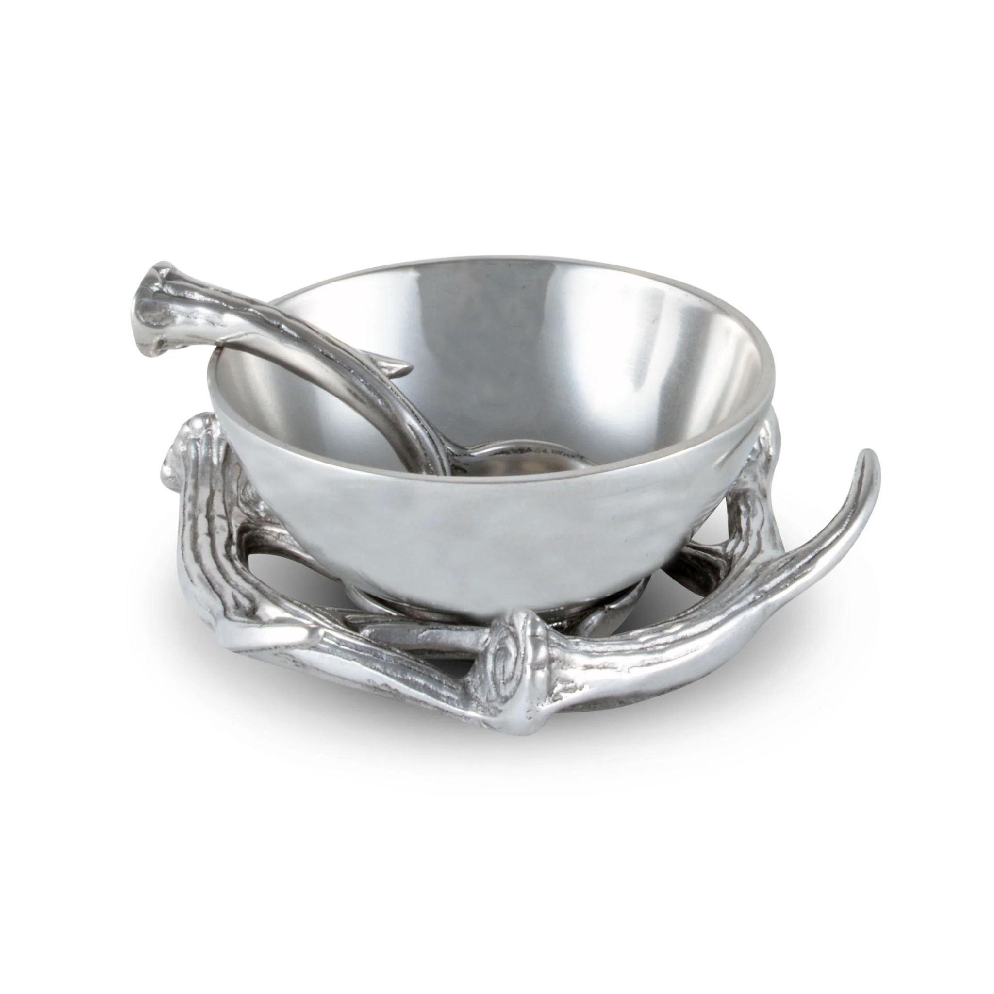 an aluminum serving bowl with antler base and spoon