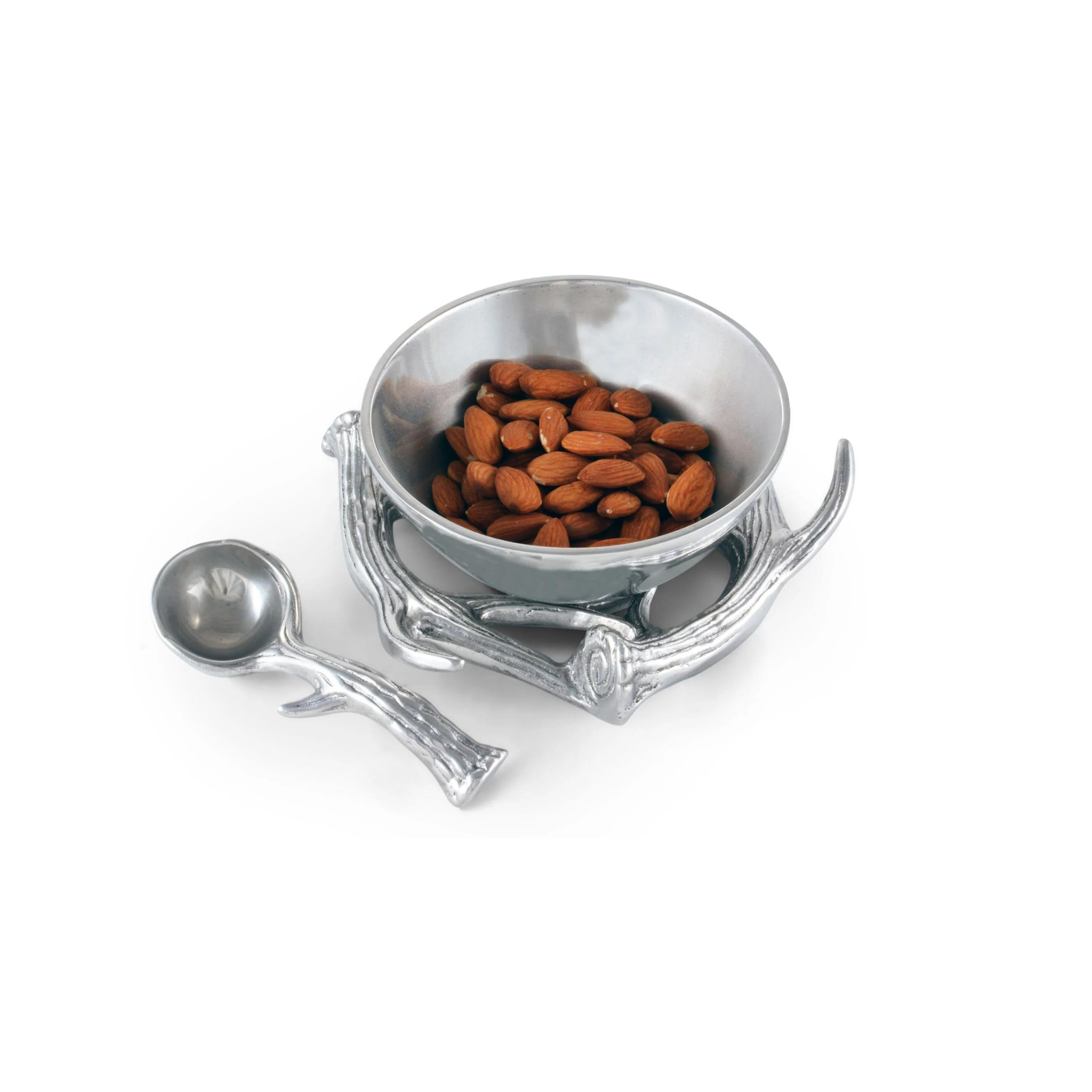 an aluminum serving bowl with antler base and spoon filled with nuts