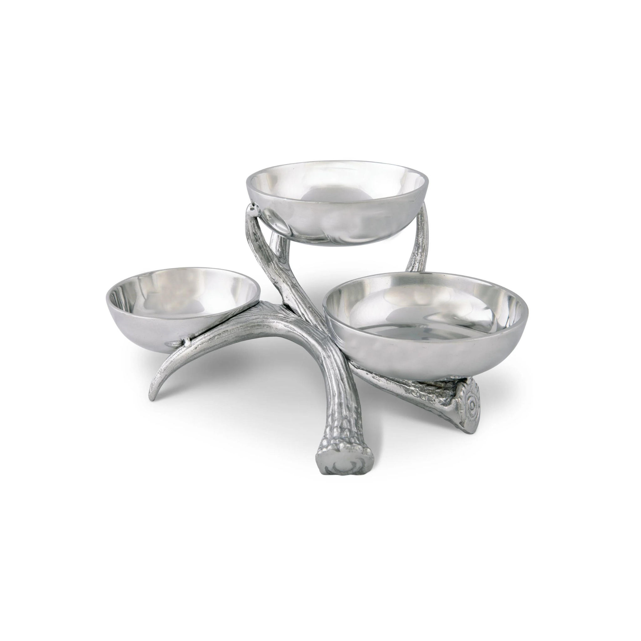 three metal serving bowls sitting on a metal antler