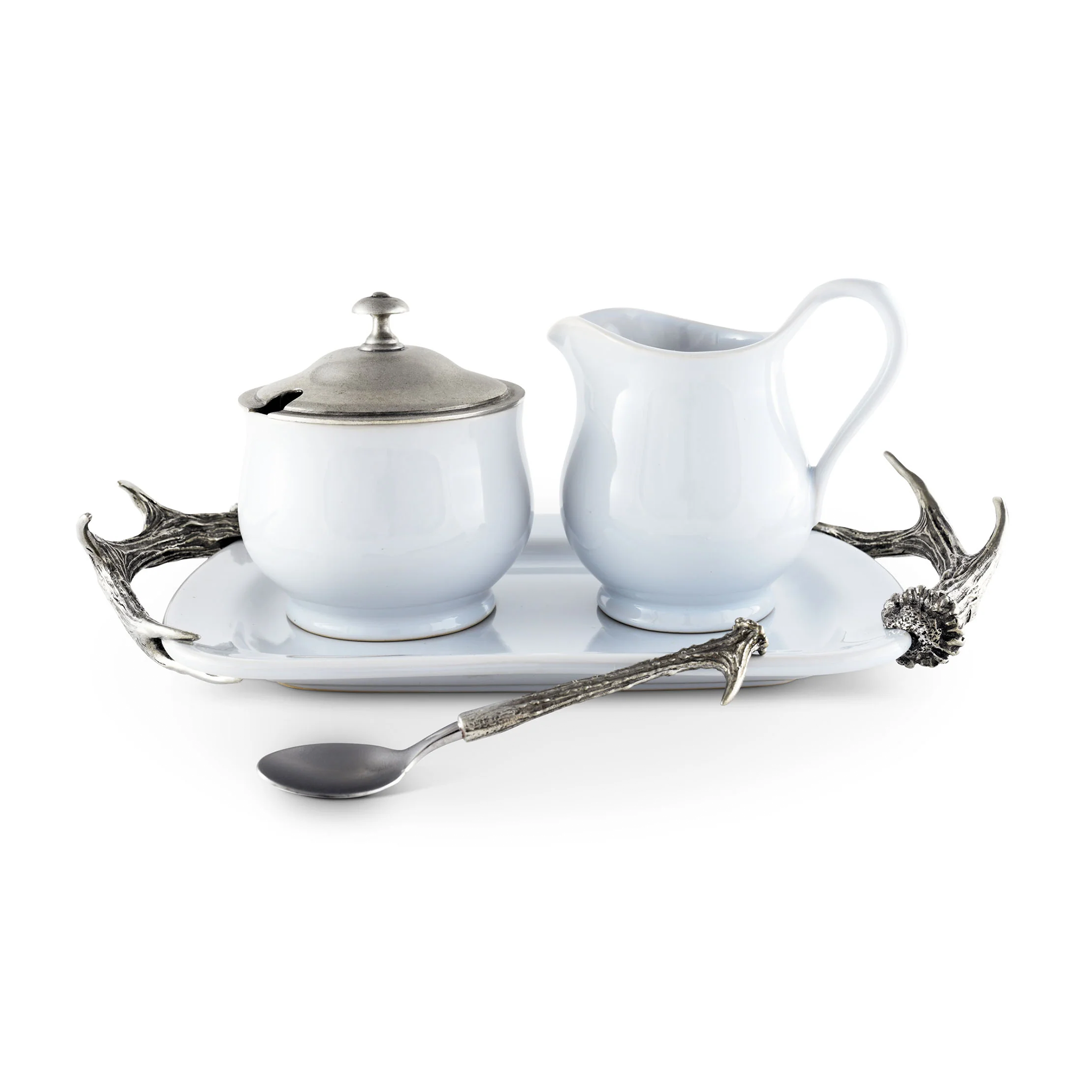 a porcelain and pewter creamer set and tray on a white surface