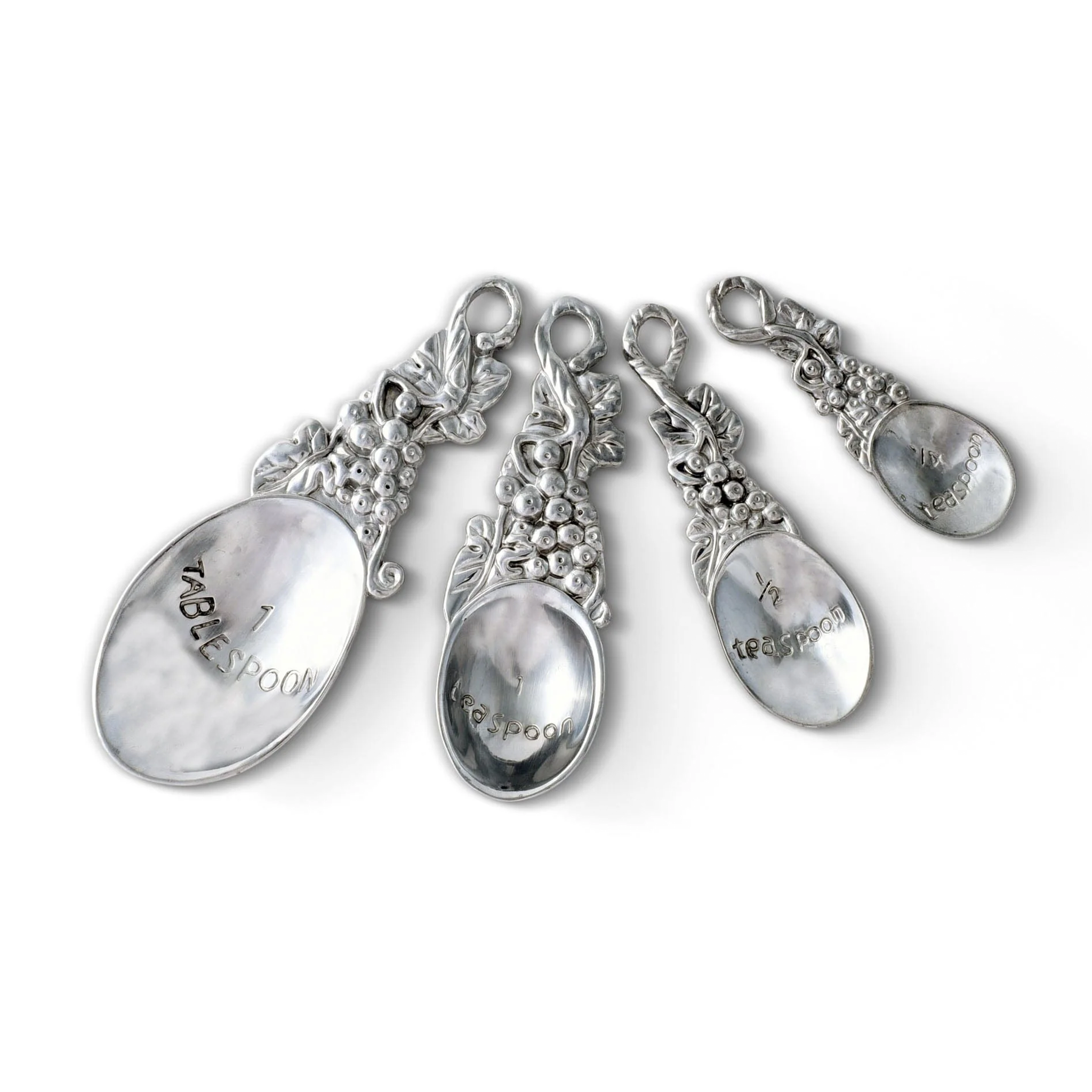 a set of four metal measuring spoons with intricate grape, leaves, and vines pattern on them