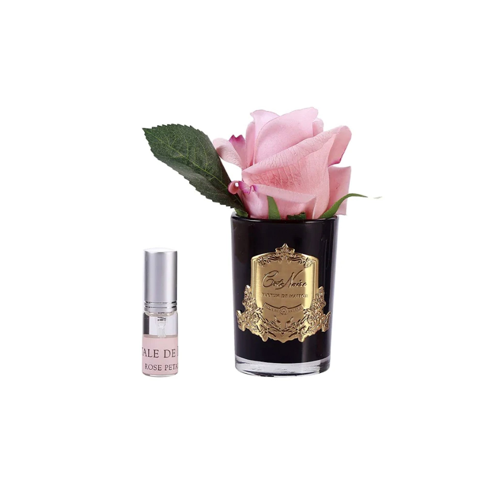 a bottle of fragrance next to a pink rose in a black vase
