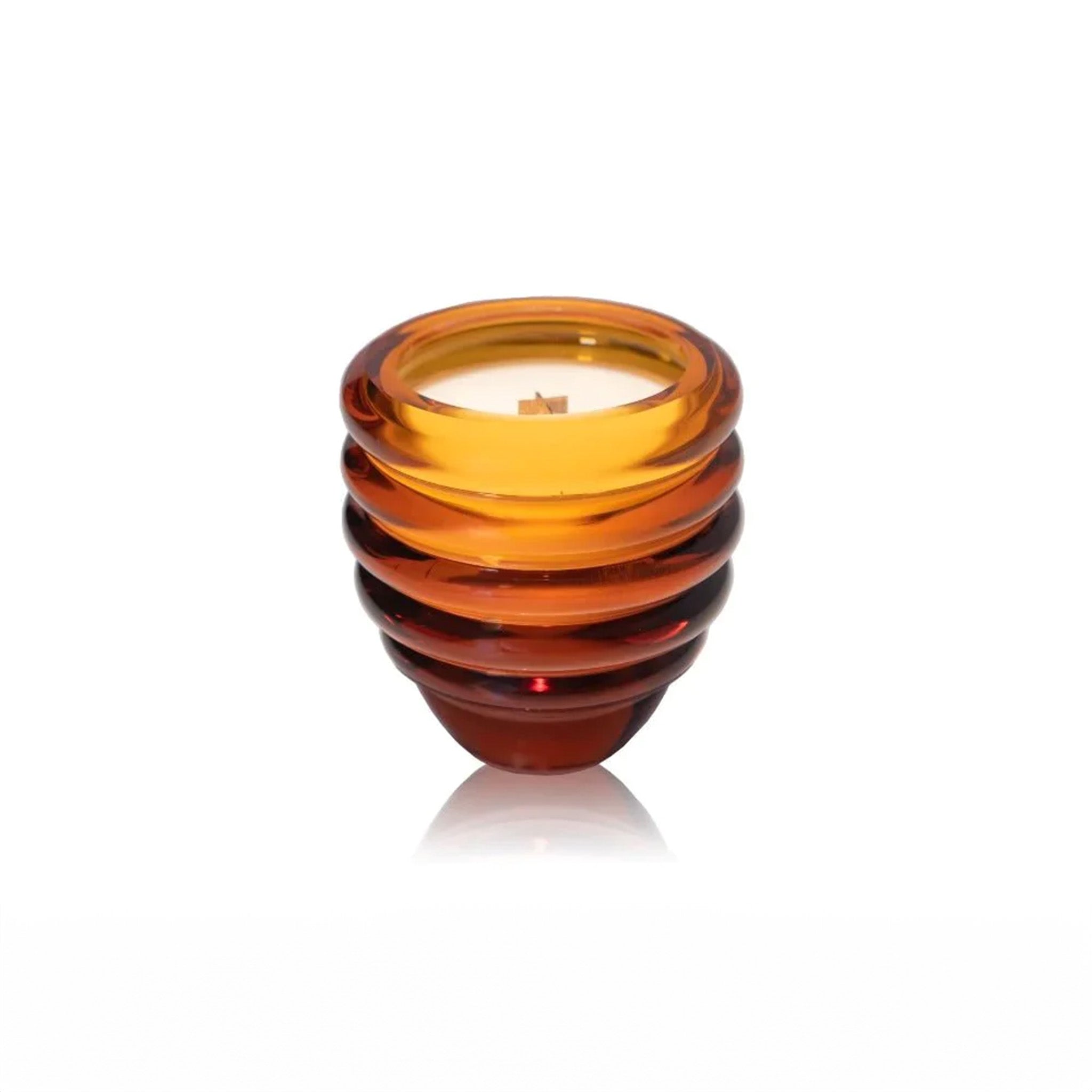 a glass amber candle sitting on top of a table