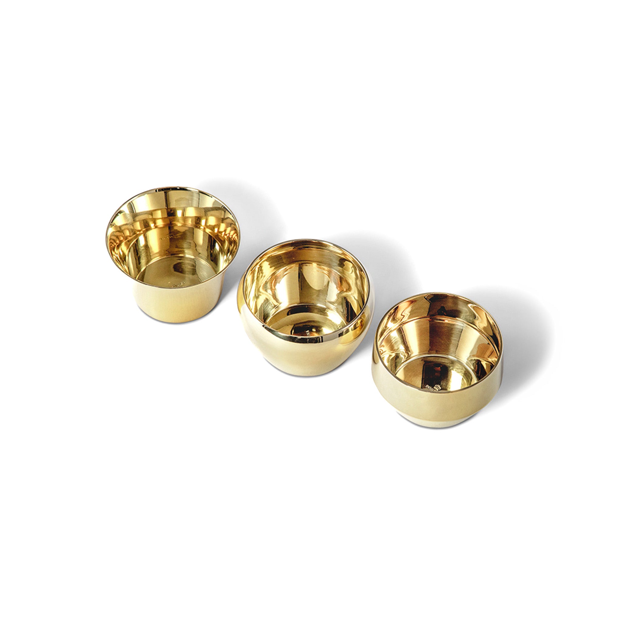 three brass tealights by skultunasitting next to each other in a top view