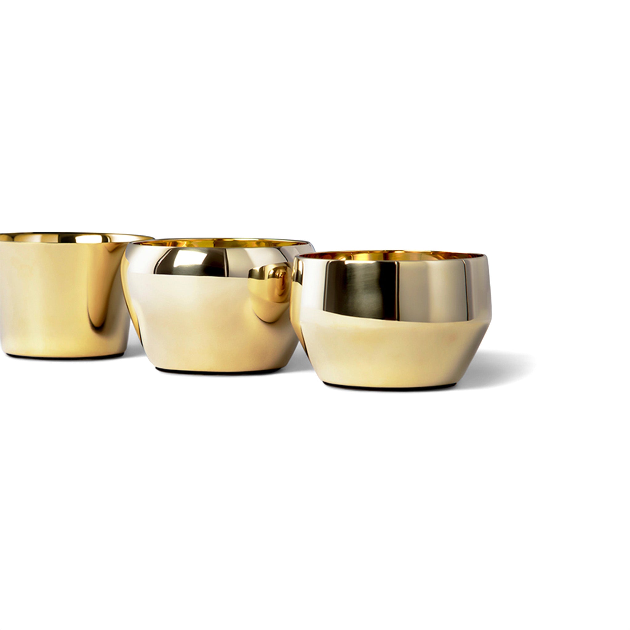 three brass tealights by skultuna sitting next to each other in a close up side view