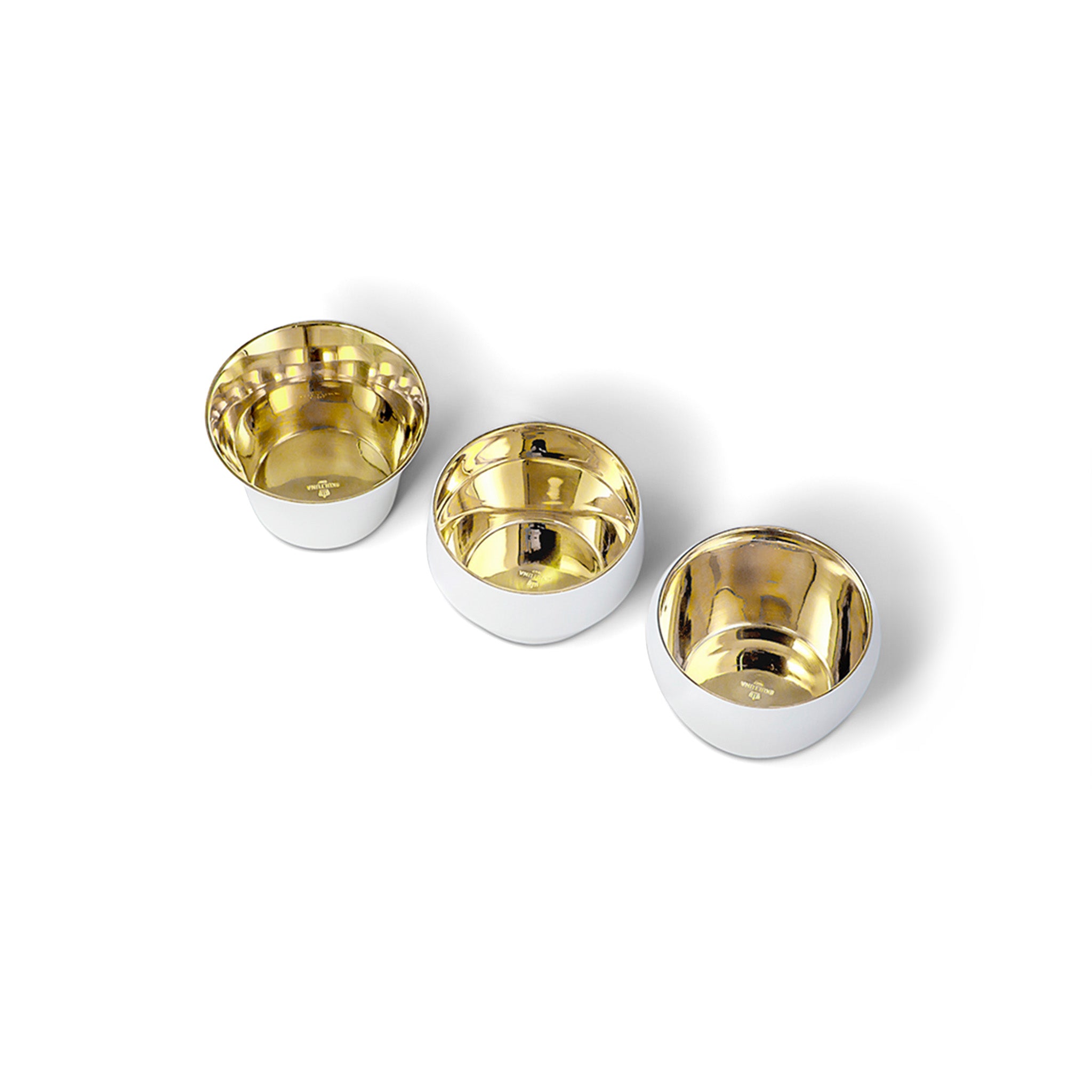 three white and brass tealights by skultuna on a white background