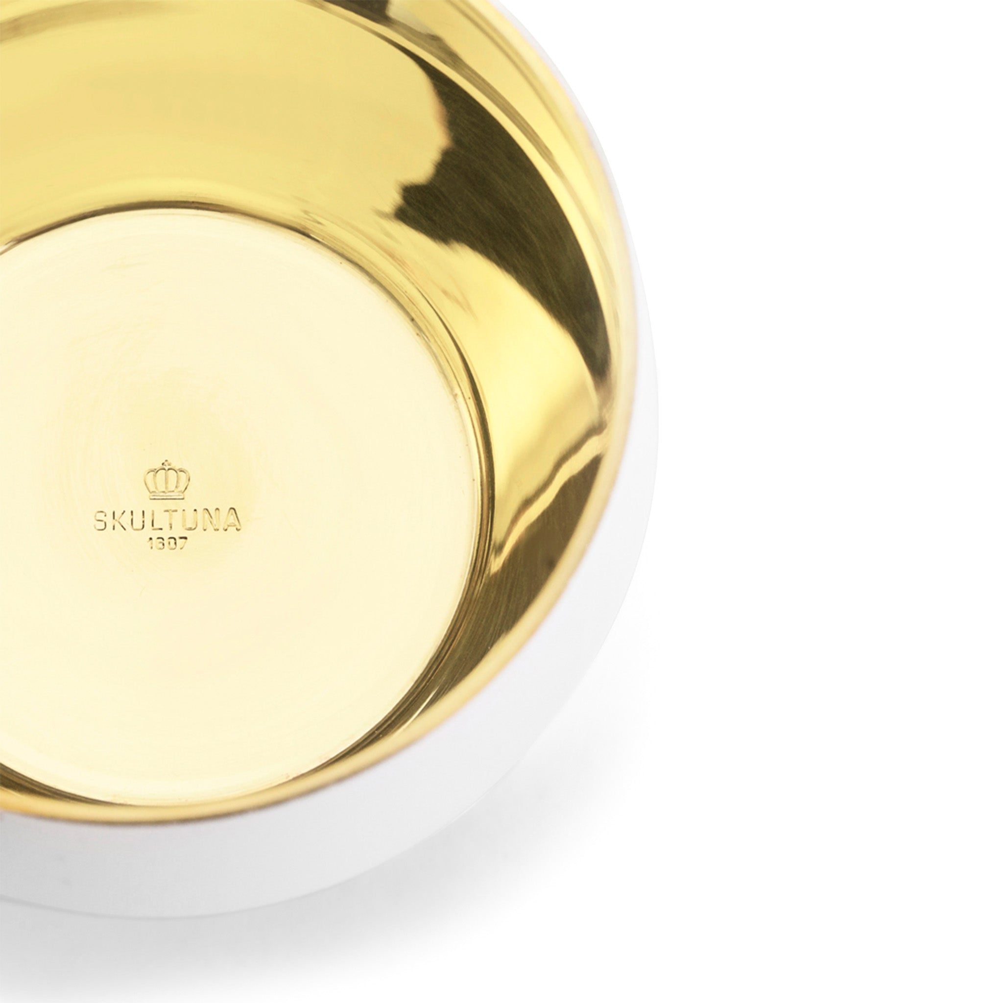 close up of white and brass tealight by skultuna on a white background