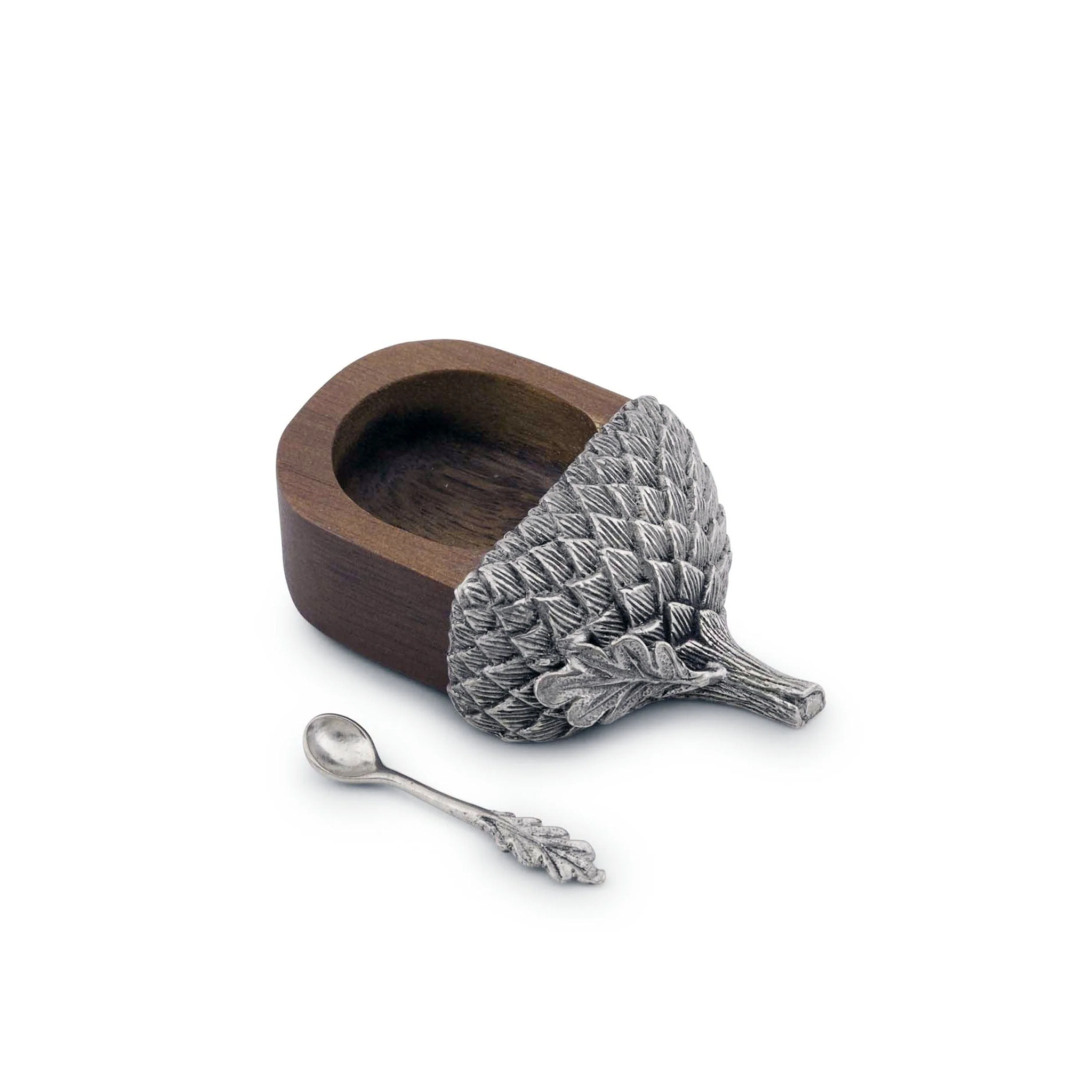 a small wooden acorn salt cellar with a silver spoon with a pewter cap on it on a white background