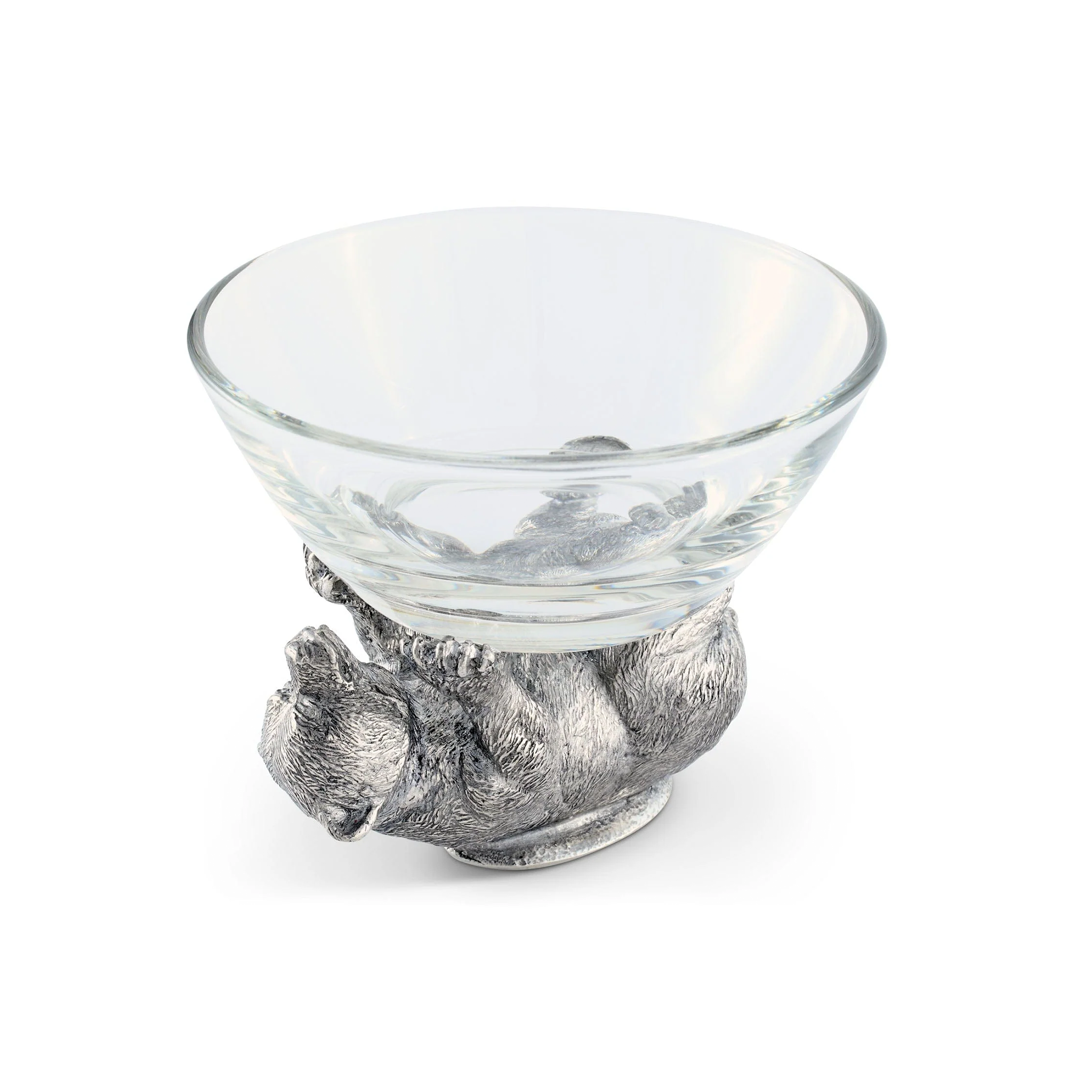 a glass bowl with a pewter bear figurine holding it