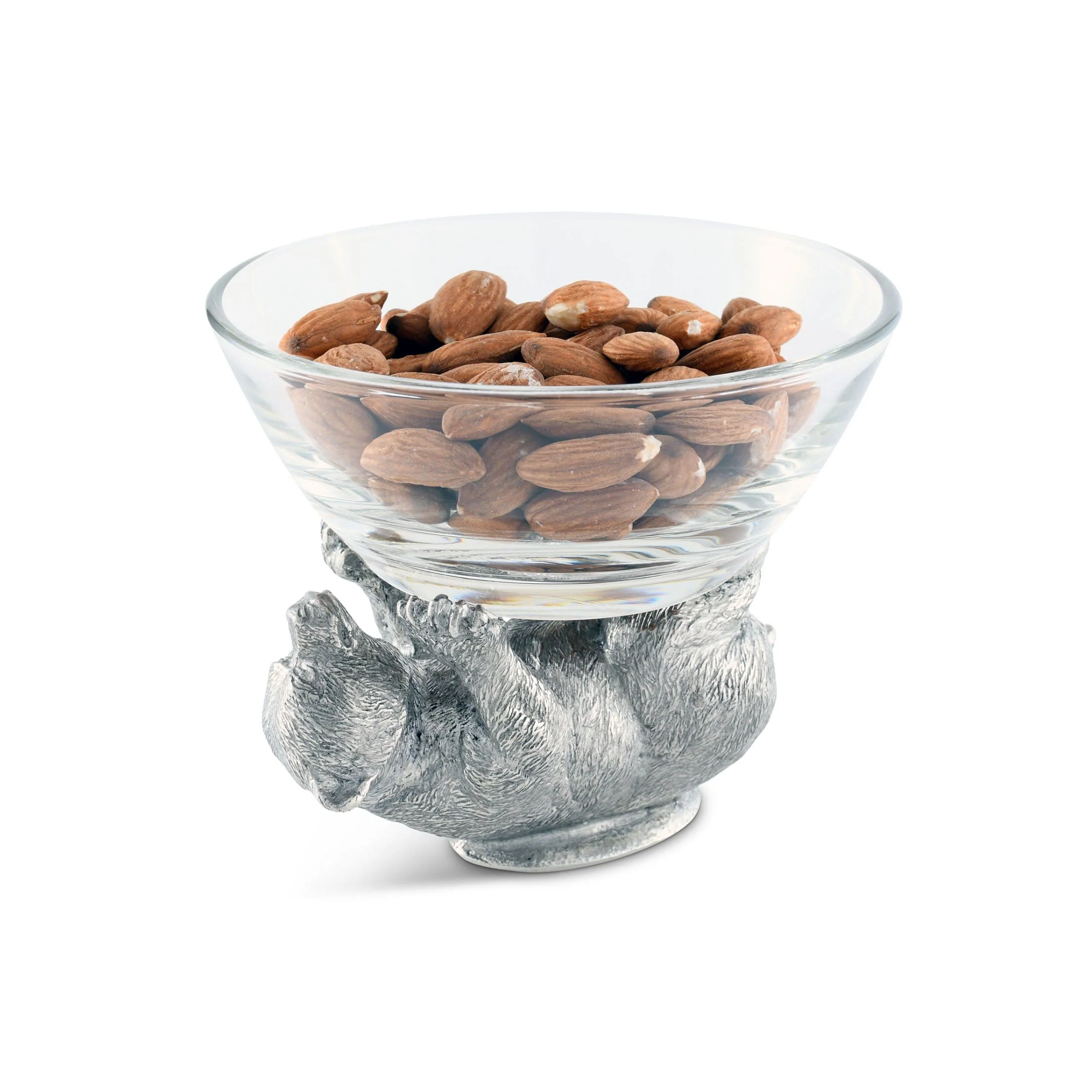 a glass bowl with a pewter bear figurine holding it filled with nuts