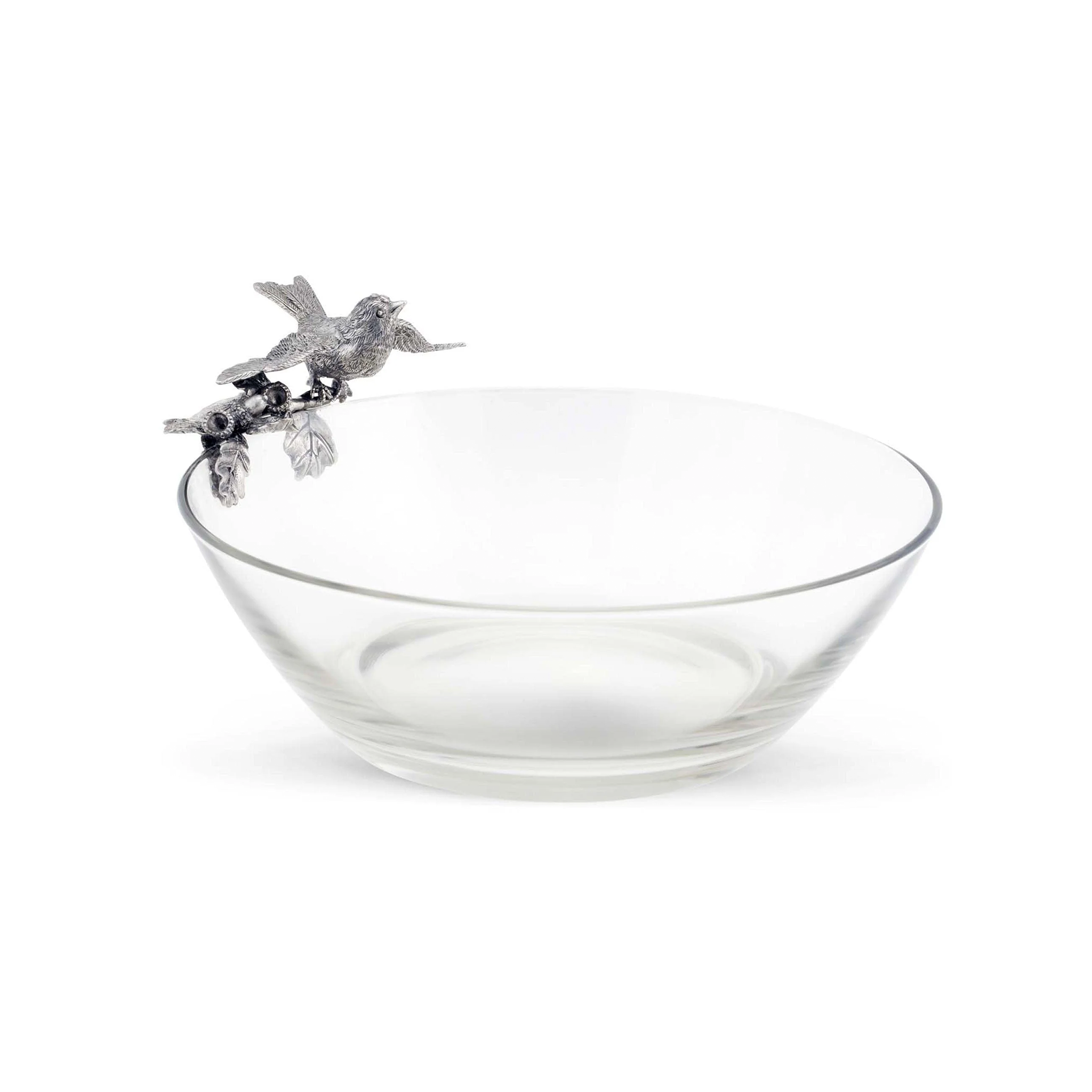 a glass serving bowl with a pewter bird on top of it