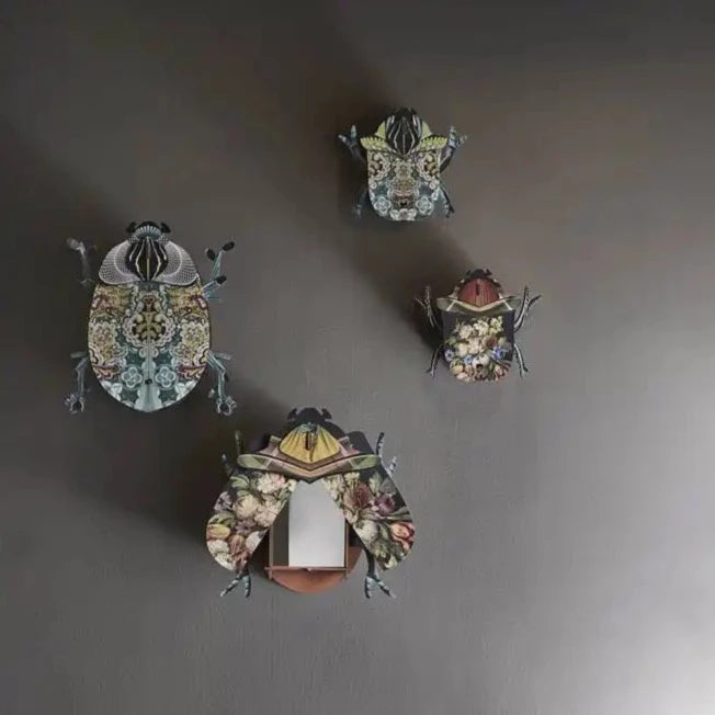 a group of four bug wall decor on a wall