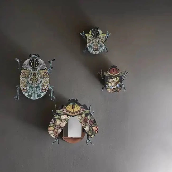 a group of four decorative beetles hangings on a wall